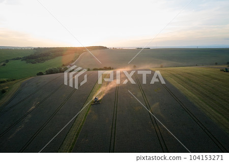 Aerial view of combine harvester working during harvesting season on large ripe wheat field. Agriculture concept Aerial view of combine harvester working during harvesting season on large ripe wheat field. Agriculture concept 104153271