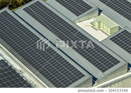 Aerial view of blue photovoltaic solar panels mounted on industrial building roof for producing green ecological electricity. Production of sustainable energy concept 104153340