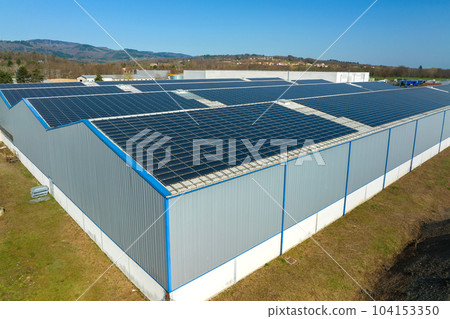 Aerial view of blue photovoltaic solar panels mounted on industrial building roof for producing green ecological electricity. Production of sustainable energy concept 104153350