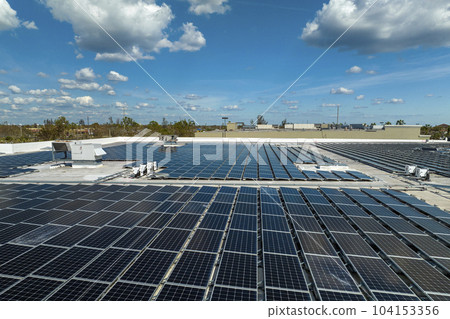 Aerial view of blue photovoltaic solar panels mounted on industrial building roof for producing green ecological electricity. Production of sustainable energy concept 104153356