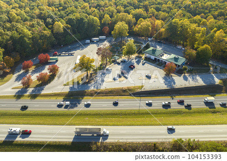 Aerial view of big rest area near busy american freeway with fast moving cars and trucks. Recreational place during interstate travel concept 104153393
