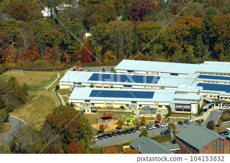 Aerial view of american school building with rooftop covered with photovoltaic solar panels for production of electric energy Aerial view of american school building with rooftop covered with photovoltaic solar panels for production of electric energy 104153832