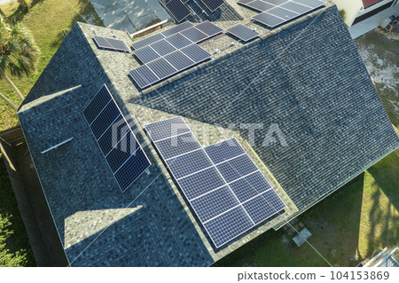 Aerial view of american building roof with blue solar photovoltaic panels for producing clean ecological electric energy. Investing in renewable electricity for retirement income concept 104153869