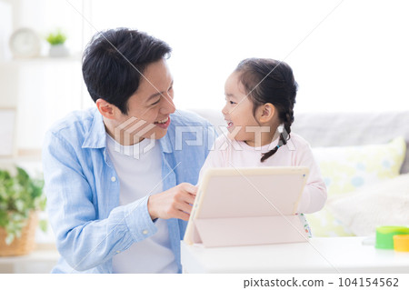 女孩和她的父親一起在平板電腦上觀看視頻 104154562