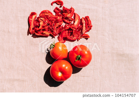 Fresh and dried tomatoes lie on the kitchen table, top view. Harvesting and processing of vegetables, vegetarianism 104154707