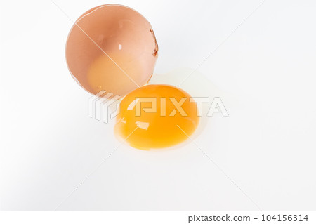 Yolk in an eggshell on a white background. Yolk in an eggshell on a white background. 104156314