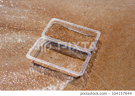 Plastic food container on the beach Plastic food container on the beach 104157644
