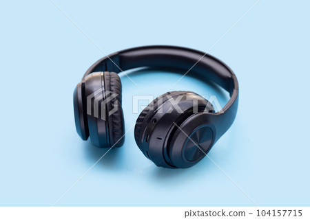 Black headphones on blue background. Black headphones on blue background. 104157715