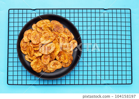 Banana slice chips on blue background Banana slice chips on blue background 104158197