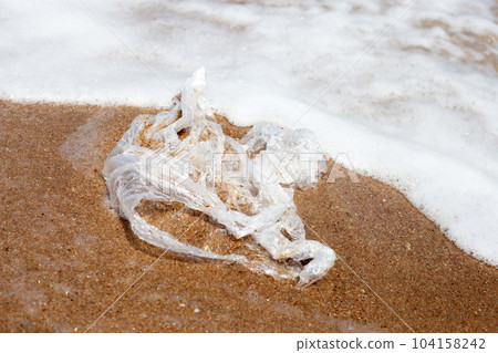 Plastic bag pollution on the beach 104158242
