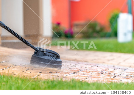 detail of machine cleaning concrete pavement in front of the house with a brush, copy space 104158460