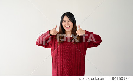 A charming Asian woman is showing her thumbs up to the camera. Great, Awesome, Cool A charming Asian woman is showing her thumbs up to the camera. Great, Awesome, Cool 104160924