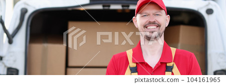 Smiling male courier pulling box in background of car Smiling male courier pulling box in background of car 104161965