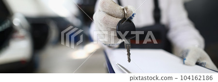 Auto mechanic holds clipboard and car keys Auto mechanic holds clipboard and car keys 104162186