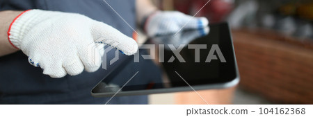 Builder hands in gloves use tablet for building and repairing premises Builder hands in gloves use tablet for building and repairing premises 104162368
