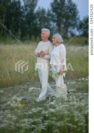 Happy nice mature couple walking together outdoors 104162426