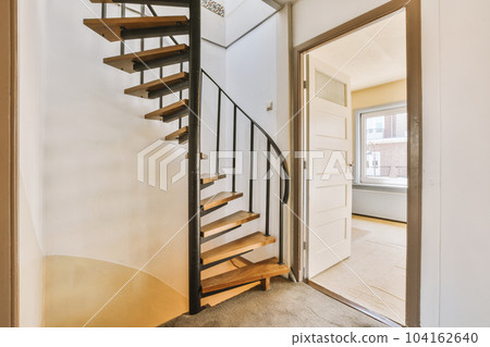 the inside of a house with wood and metal staircase leading up to an open door that leads to another room the inside of a house with wood and metal staircase leading up to an open door that leads to another room 104162640