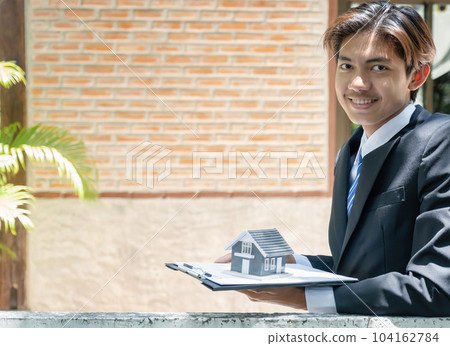 Real estate agent holding home model and explain the business contract, rent, buy mortgage, loan, or insurance Real estate agent holding home model and explain the business contract, rent, buy mortgage, loan, or insurance 104162784