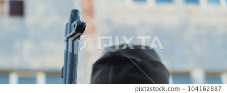 Back view of unrecognizable man in body armor during war weapon. Soldier hold the gun next to building wall. War preparation 104162887