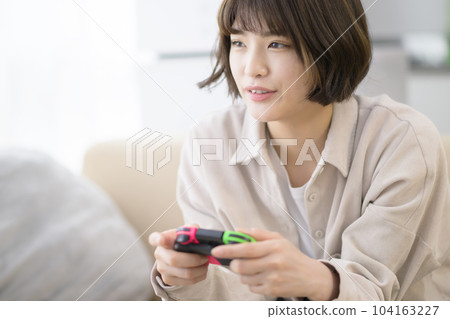 young woman playing video games young woman playing video games 104163227