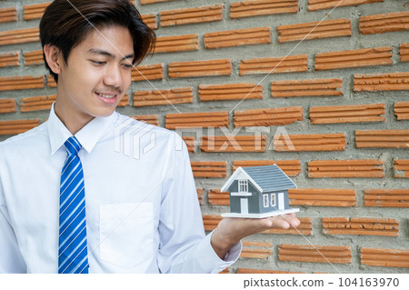 Real estate agent holding home model and explain the business contract, rent, buy mortgage, loan, or insurance 104163970