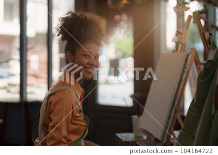 Beautiful american african artist woman painting in art studio at the university classroom 104164722