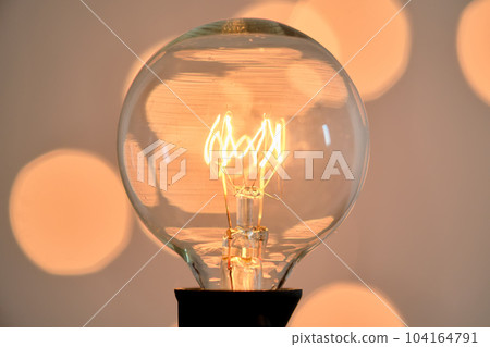 Incandescent light bulb with christmas round bokeh. Incandescent light bulb with christmas round bokeh. 104164791