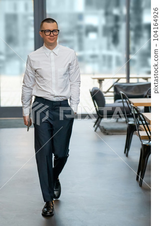 Man in formal wear carrying laptop walking to cafe for remote work. Man in formal wear carrying laptop walking to cafe for remote work. 104164926