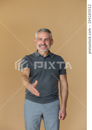 Positive businessman stretching his hand for a handshake 104165012