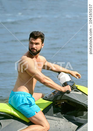 Young handsome man on jet ski on tropical ocean vacation enjoying holiday at resort. Young handsome man on jet ski on tropical ocean vacation enjoying holiday at resort. 104165037