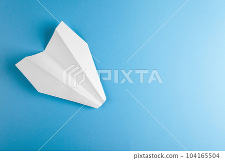 Flat lay of white paper plane on pastel blue color background 104165504