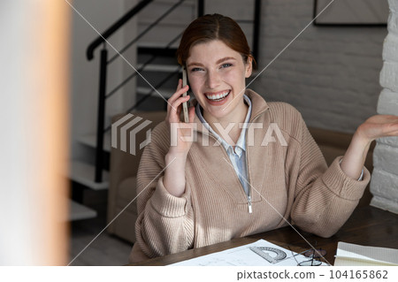 Smiling young woman talking on the phone and feeling excited Smiling young woman talking on the phone and feeling excited 104165862