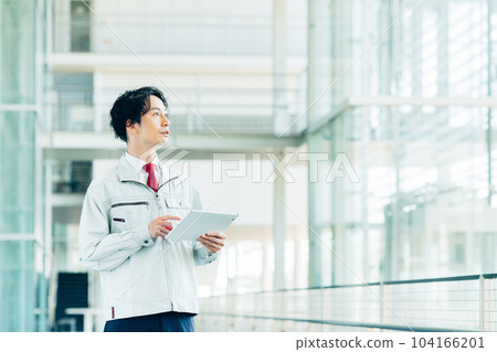 A worker carrying out an inspection with a tablet in an office building 104166201