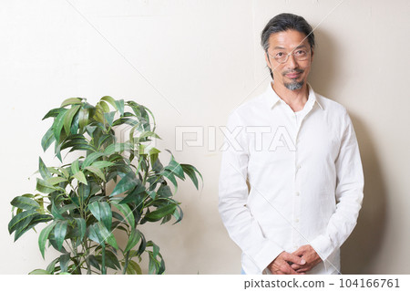 一位中年男子站在牆邊隨意地看著自己的肖像 104166761