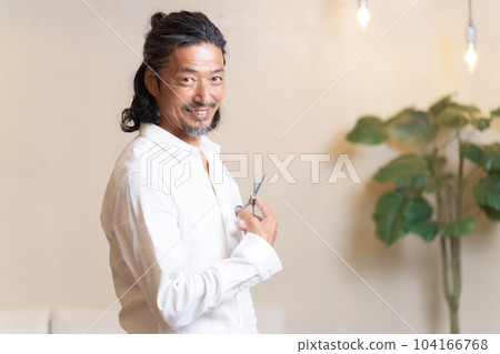 Veteran hair stylist holding scissors and posing Veteran hair stylist holding scissors and posing 104166768