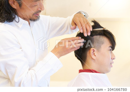 Hairdresser's hand and customer's profile Hairdresser's hand and customer's profile 104166780