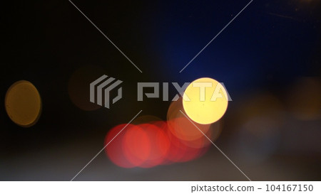 Blurred lights evening city traffic bokeh. Defocused night city traffic. Blurred lights bokeh car headlights driving evening city road. City night traffic background 104167150