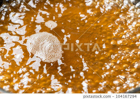 將高湯放入煎鍋中煮沸的烹飪場景。 104167294