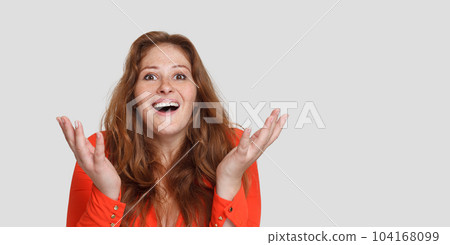 Surprised attractive redhead woman with opened mouth looking at camera on white studio background 104168099
