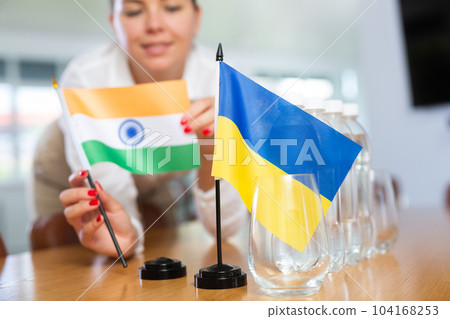 Flags of India and Ukraine in female hands preparing for international negotiations 104168253