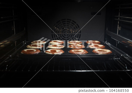 Homemade baking chocolate cupcakes in the oven. Sweet cakes. Cooking process of muffins. 104168550