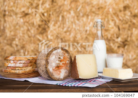 whole head of ripe country cheese and slices and milk in hayloft whole head of ripe country cheese and slices and milk in hayloft 104169047