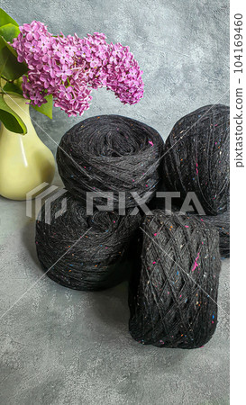 Knitted handmade products. Knitted sweater made of tweed threads. Gray background. Knitted handmade products. Knitted sweater made of tweed threads. Gray background. 104169460