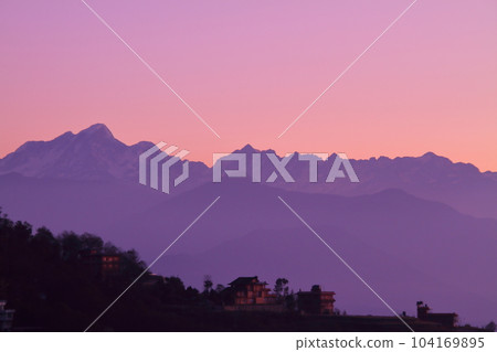 View of the Himalayas at sunrise from Nagarkot, a village on the outskirts of Kathmandu, Nepal in South Asia View of the Himalayas at sunrise from Nagarkot, a village on the outskirts of Kathmandu, Nepal in South Asia 104169895