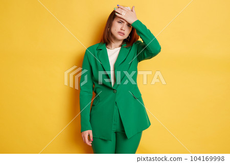 Indoor shot of displeased worried Caucasian young woman wearing stylish green jacket posing isolated over yellow background, standing with facepalm gesture, forgot something important. Indoor shot of displeased worried Caucasian young woman wearing stylish green jacket posing isolated over yellow background, standing with facepalm gesture, forgot something important. 104169998