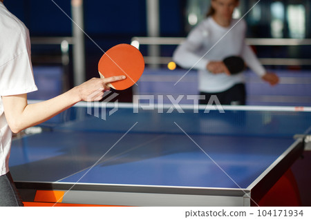Selective focus on two sportive people playing table tennis indoors 104171934