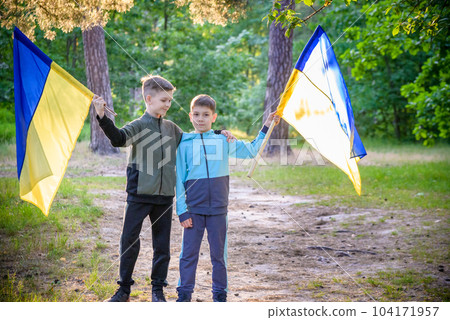 flags of Ukraine in hands of two boys. Children hold Ukrainian f flags of Ukraine in hands of two boys. Children hold Ukrainian f 104171957