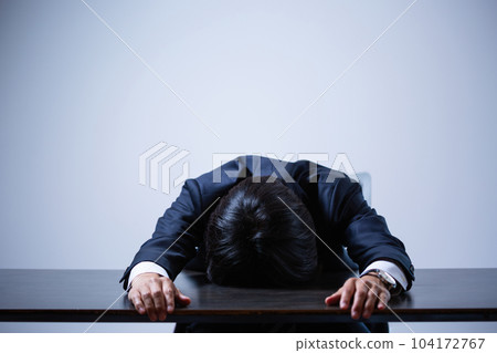 businessman depressed at office desk businessman depressed at office desk 104172767