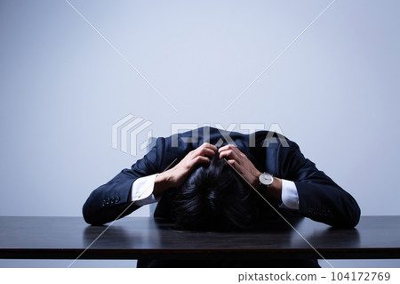 businessman depressed at office desk businessman depressed at office desk 104172769
