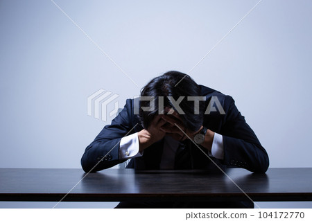 businessman depressed at office desk businessman depressed at office desk 104172770